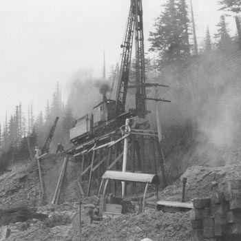 A pile driver builds a trestle during the construction of the Spokane, Portand & Seattle Railway